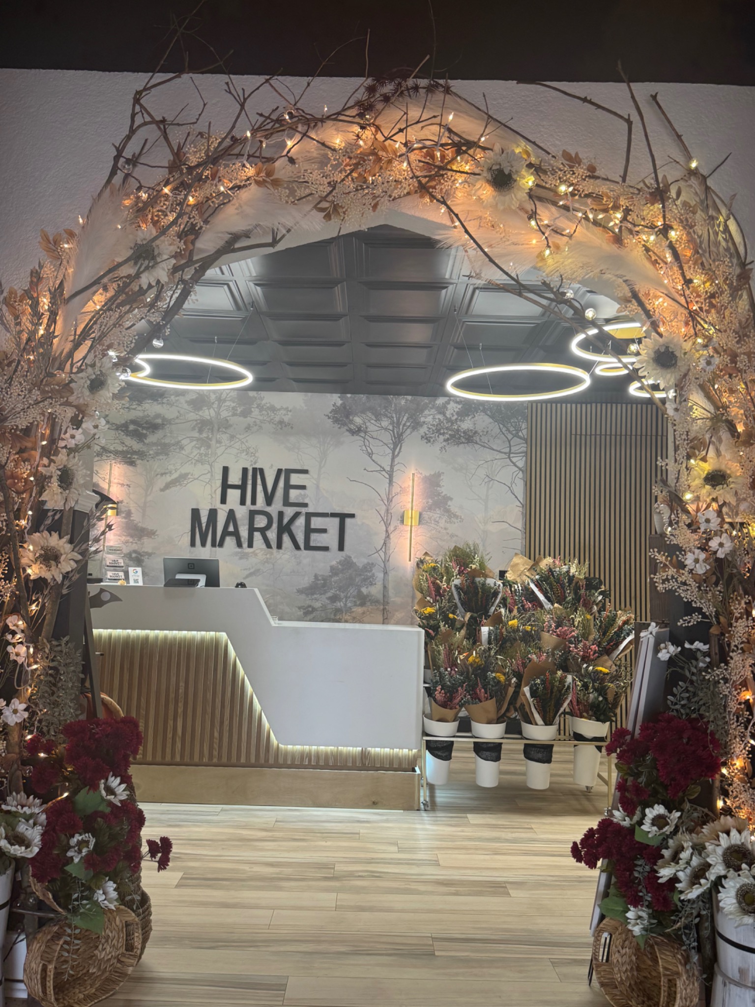 The floral-lit entrance and curated displays inside the HIVE Market